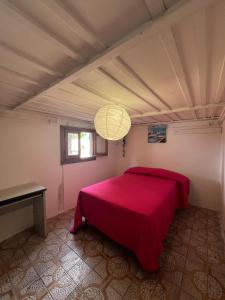 a bedroom with a red bed and a window at BELLA VILLA TRA MARE e LAGO in Sperlonga
