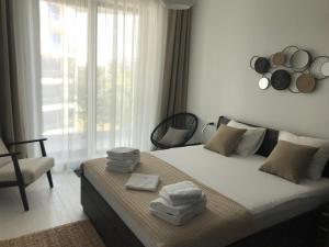 a bedroom with a bed with towels on it at Ammos Apartment Mamaia in Mamaia