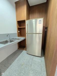 Una cocina con frigorífico de acero inoxidable y fregadero. en Family room, en Ban Phayun