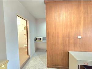 Un baño con puerta de madera con microondas. en Family room, en Ban Phayun