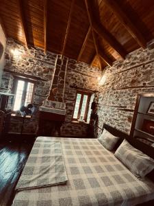 a bedroom with a bed in a stone building at Villa Tzeni Palios Panteleimon in Panteleímon