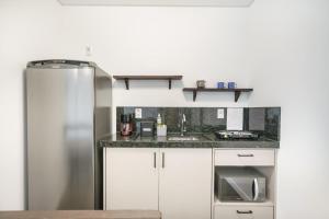 A cozinha ou cozinha compacta de Banzai Brava Suítes