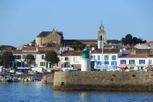 a town with a harbor and a lighthouse on the water at Atlantic Hôtel - L'Ile d'Yeu in L'Ile d'Yeu