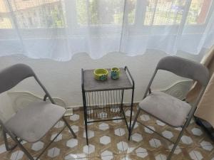 two chairs and two cups on a table in front of a window at Apartament La Ilie in Ocna Sibiului