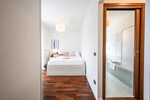 - une chambre blanche avec un lit et une baignoire dans l'établissement Casa Albertina [Grazioso appartamento vicino alla Stazione], à Monza