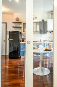 Il comprend une cuisine équipée d'un réfrigérateur noir et d'une table. dans l'établissement Casa Albertina [Grazioso appartamento vicino alla Stazione], à Monza