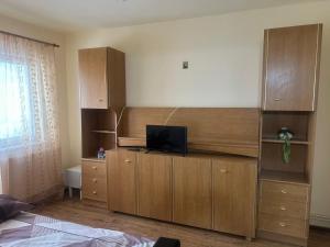 a room with a tv on top of a wooden cabinet at Apartament La Ilie in Ocna Sibiului