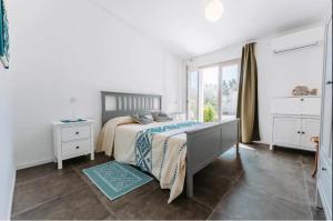 een witte slaapkamer met een bed en een raam bij Tenuta Naturale in Villa San Pietro +88 foto's