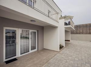 an empty house with a balcony and a patio at Holiday Home Milutin 1 in Vrsi +34 photos