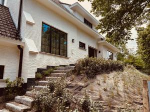 a white house with stairs leading up to it at Maison Marelle in Koksijde