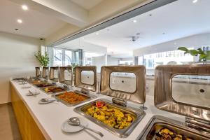 a buffet line with many trays of food at White Olive Premium Laganas in Laganas