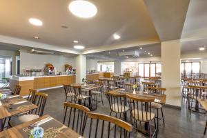 a dining room with wooden tables and chairs at White Olive Premium Laganas in Laganas