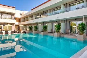a swimming pool in front of a hotel at White Olive Premium Laganas in Laganas