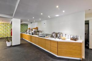 a large kitchen with a counter with many appliances at White Olive Premium Laganas in Laganas