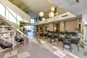 a dining room with tables and chairs in a building at White Olive Premium Laganas in Laganas