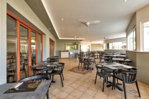 a dining room with tables and chairs in a restaurant at White Olive Premium Laganas in Laganas