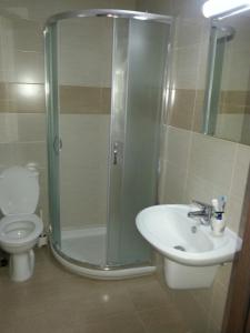 een badkamer met een douche, een wastafel en een toilet bij Potamos Apartment in Limassol