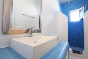 a bathroom with a white sink and a mirror at Blue Studio at Cavo Delos in Agios Ioannis Mykonos