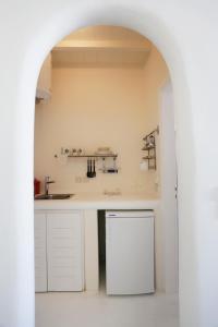 a kitchen with white cabinets and a sink at Blue Studio at Cavo Delos in Agios Ioannis Mykonos