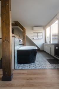 a bathroom with a bath tub in the middle of a room at B&B Hartenlust kamer de Hooizolder in Bodegraven
