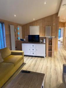 un salon avec un canapé et une télévision à écran plat dans l'établissement The Shore, à Eyemouth