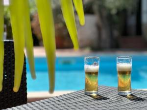 two glasses of beer sitting on a table next to a pool at Villa Monica appartamenti in Vieste