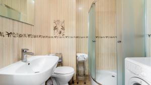 a bathroom with a sink and a toilet and a shower at Osiedle Bursztynowe in Jantar +21 photos