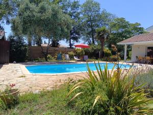 a swimming pool in the yard of a house at Villa Naturéa in Messanges