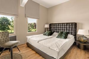 a bedroom with a large bed and a chair at Harmonija HOTEL & PADEL in Mengeš