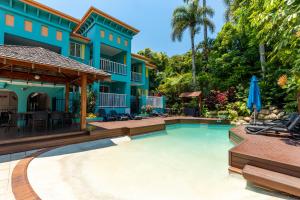 una piscina frente a una casa en CASA PAPAYA Adults Only Apartment, en Port Douglas