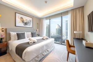 a bedroom with a large bed with a desk and a large window at Address Opera Residences Burj Khalifa View in Dubai +146 photos