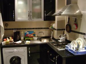 a kitchen with a sink and a washing machine at Studio Résidence Neptune Sousse Zone Kantaoui in Port El Kantaoui