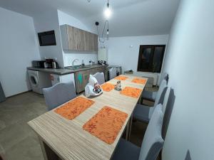 a kitchen with a long table with chairs in a kitchen at Alexander Residence in Brăila