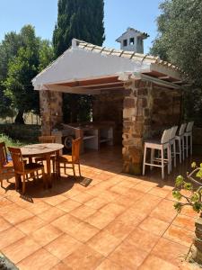 a patio with a table and chairs and a stone building at Villa Natalia in La Zarzuela