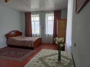 a bedroom with a bed and a vase of flowers on a table at Vamesa in Haghpat