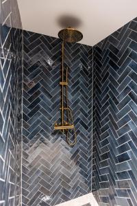 a bathroom with blue tiles on the walls and a chandelier at 6 persons Luxury Appartement in Citycentre Breda in Breda