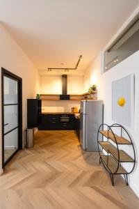 a kitchen with a stainless steel refrigerator and wooden floors at 6 persons Luxury Appartement in Citycentre Breda in Breda +18 photos