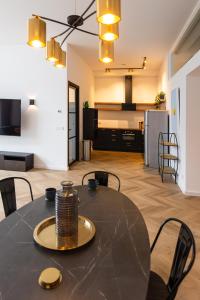 a dining room table with chairs and a kitchen in the background at 6 persons Luxury Appartement in Citycentre Breda in Breda