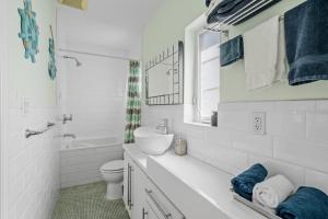 Un baño blanco con lavabo e inodoro. en villa venezia bb, en Miami Beach 37 fotos más