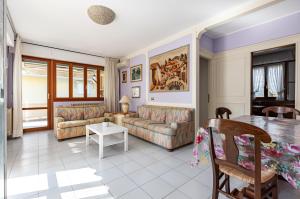a living room with couches and a table at Two-Levels Apartment with Terrace and Parking in Viareggio +9 photos