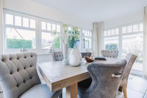 a dining room with a wooden table and chairs at Villa Strandleben in Zingst
