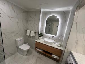 Un baño con inodoro, lavabo y espejo. en ADELAIDE CBD APARTMENT - 3BR, 2BATH & CARPARK, en Adelaida 25 fotos más