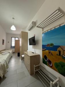 a bedroom with a bed and a tv on a wall at Casa Vacanze Il Borghetto in Marzamemi