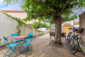 a table and chairs and a bike parked next to a tree at Villa de famille Maragre, au calme in Sainte-Marie-la-Mer