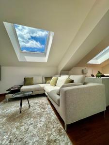Una sala de estar con un sofá y una ventana. en Romantico Attico Cuneo, en Cuneo