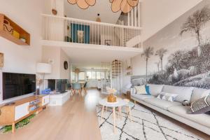 a living room with a couch and a tv at Jolie maison - 150m plage du Fogeo et du port in Arzon