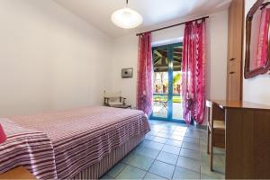 a bedroom with a bed and a sliding glass door at Casa Vacanze Villa Flumini in Flumini di Quartu