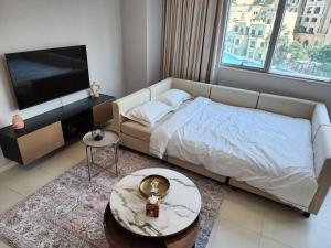 a bedroom with a bed and a flat screen tv at Downtown Oasis, Burj Khalifa Views, Luxury Amenities in Dubai
