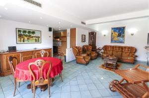 sala de estar con mesa roja y sillas en Casa Vacanze Villa Flumini, en Flumini di Quartu
