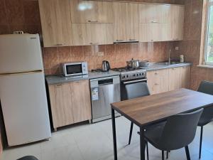 a kitchen with a table and a white refrigerator at Villa In Urekhi in Batumi